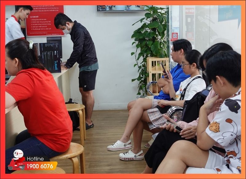 Khách hàng iCare Center ngồi chờ trong khu vực chờ tiện nghi khi máy đang vệ sinh
