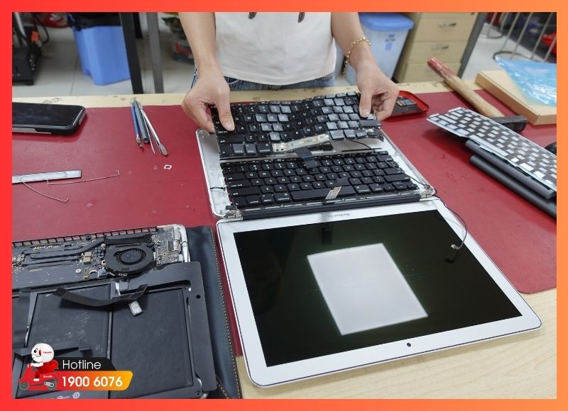 Kỹ thuật viên iCare Center vệ sinh bàn phím, màn hình và các cổng kết nối một cách tỉ mỉ